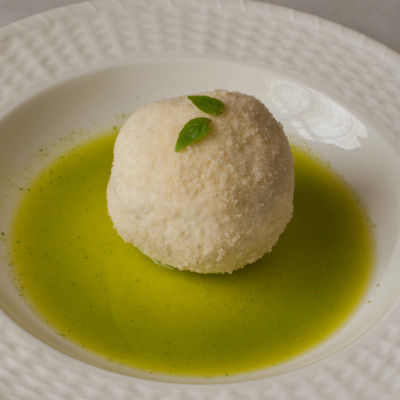 parmesan-and-panko-encrusted-goat-cheese-in-basil-olive-oil-and-basil-leaves-on-top