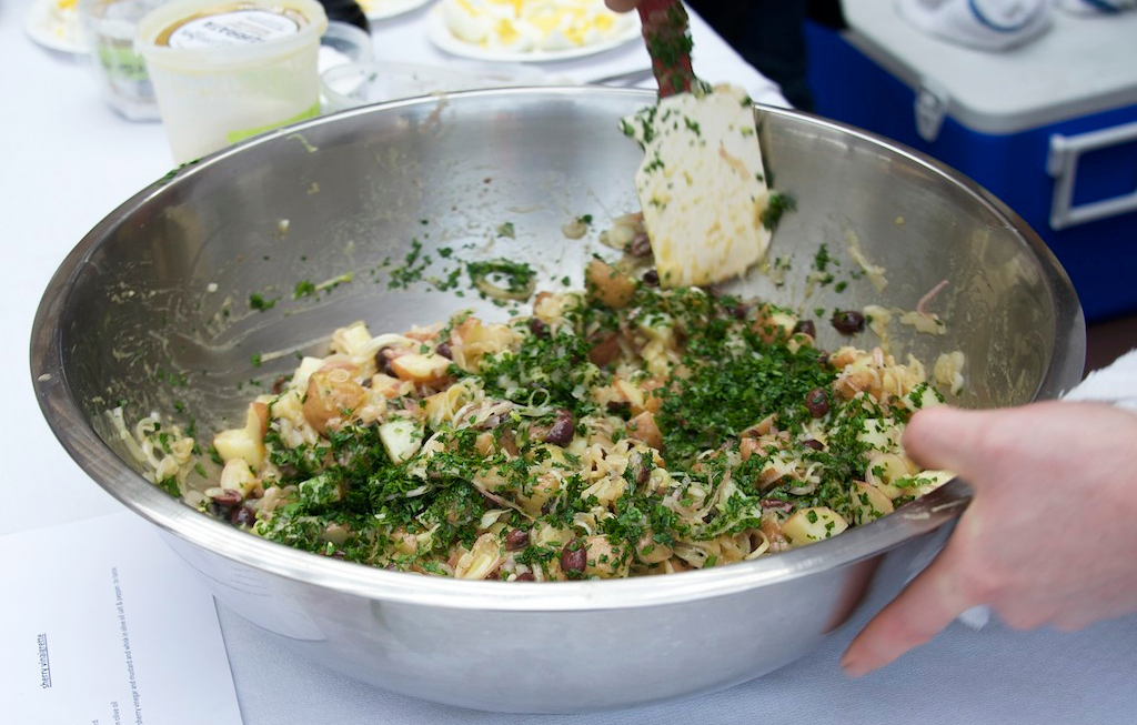 mixing-the-parsley-in-the-potato-and-torpedo-onion-salad