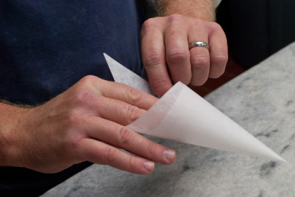 folding-in-the-top-triangle-to-make-a-parchment-pastry-bag